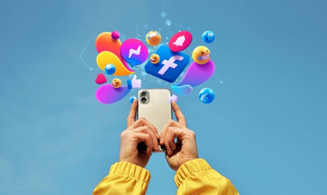 person holding phone and above it multiple social media's icon are present